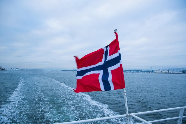 Foto bandera roja en el mar contra el cielo