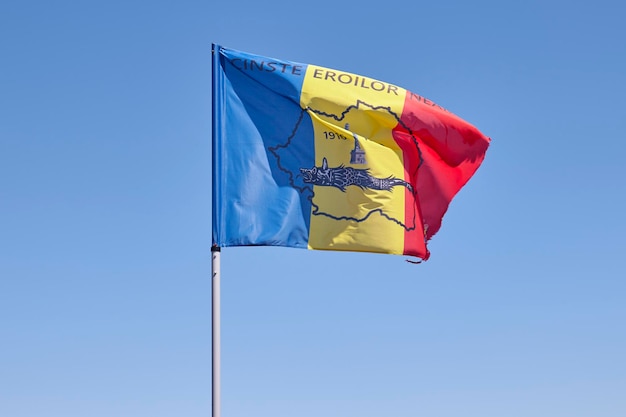 Bandera rumana en el viento en el pico de Caraiman