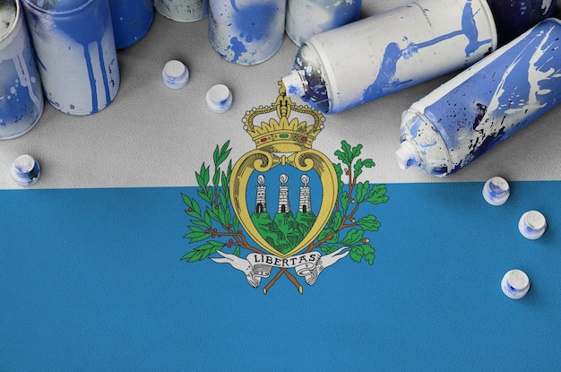 Bandera de San Marino y pocas latas de aerosol usadas para pintar graffiti Concepto de cultura de arte callejero