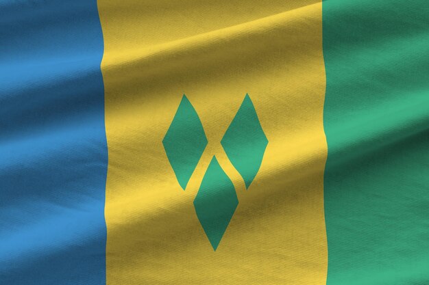 Bandera de San Vicente y las Granadinas con grandes pliegues ondeando de cerca bajo la luz del estudio en el interior Los símbolos y colores oficiales en la pancarta