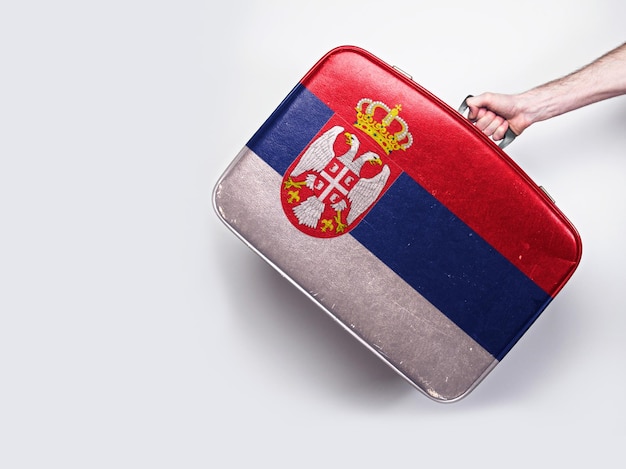 Bandera de serbia en una maleta de cuero vintage