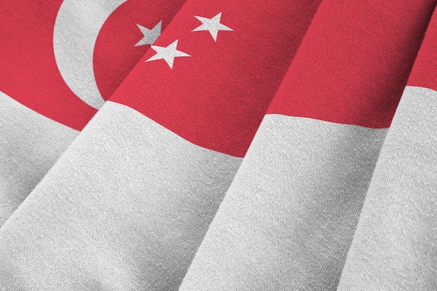 Bandera de Singapur con grandes pliegues ondeando de cerca bajo la luz del estudio en el interior Los símbolos y colores oficiales en la pancarta