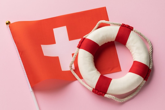 Foto bandera de suiza y boya salvavidas en el concepto de fondo de color en el tema de ayuda