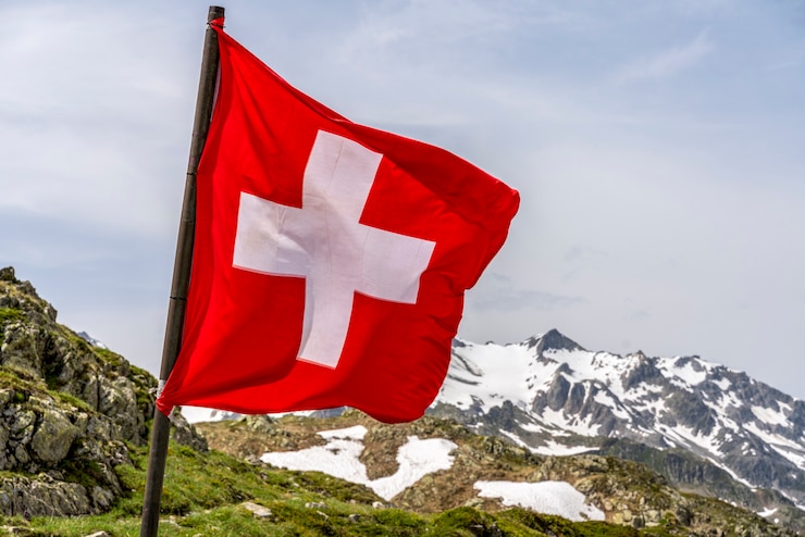 Foto bandera suiza en las montañas nevadas de los alpes - enfoque selectivo