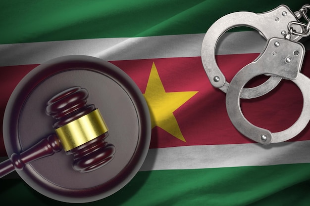 Bandera de Surinam con mazo de juez y esposas en cuarto oscuro concepto de backgr penal y castigo