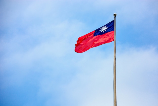 Bandera de Taiwán (República de China) ondeando en el viento en el mástil con fondo de cielo azul y nubes