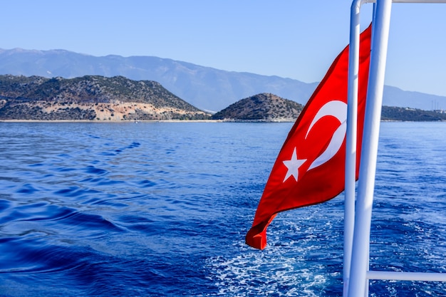 Bandera turca roja ondeando sobre el mar Mediterráneo