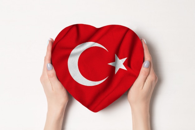 Bandera de Turquía en una caja en forma de corazón en manos femeninas