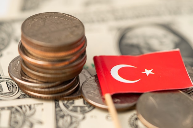 Foto bandera de turquía con monedas en billetes de dólar de fondo.