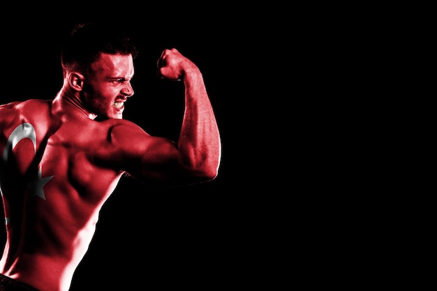 Bandera de Turquía sobre fondo negro guapo joven musculoso