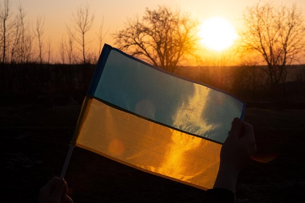 Bandera de Ucrania contra el telón de fondo de la puesta de sol de un país europeo libre Victoria ucraniana