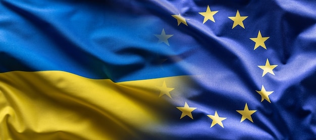 Foto la bandera ucraniana y la bandera de la ue se mezclan entre sí a medida que la unión europea se inclina hacia la adhesión de ucrania