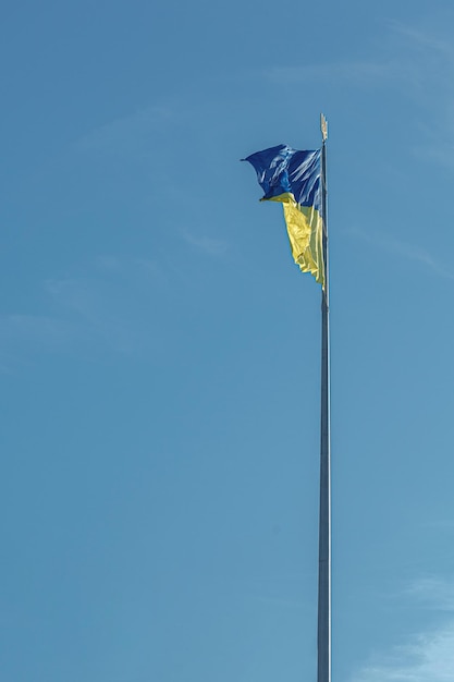 Bandera ucraniana contra el primer plano del cielo azul