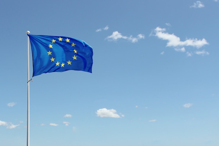 Bandera de la Unión Europea ondeando sobre fondo de cielo azul