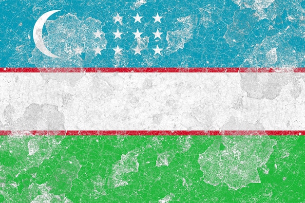 Bandera de Uzbekistán en una superficie de pared de hormigón vieja dañada