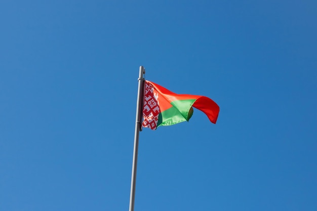 Bandera verde roja de Bielorrusia contra el cielo azul