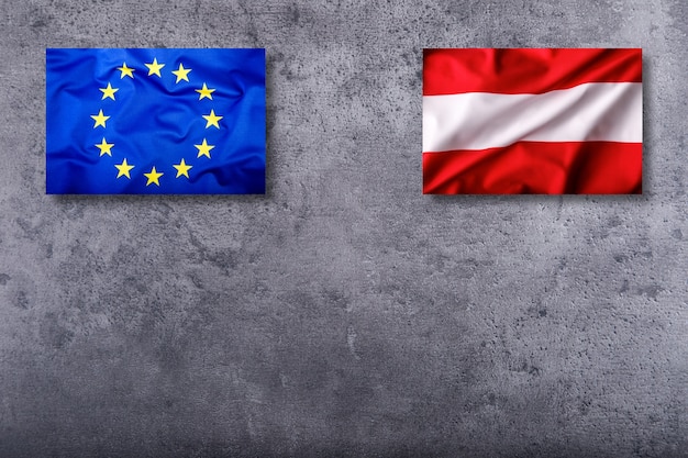 Banderas de Austria y la Unión Europea sobre fondo de hormigón.