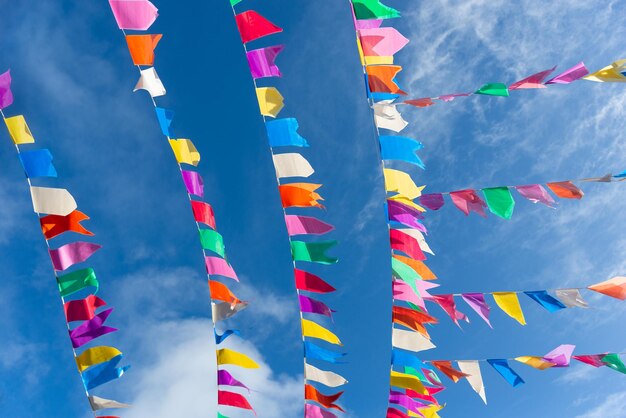 Banderas de diferentes colores colgando de una cuerda Decoración de Sao Joao contra el cielo azul