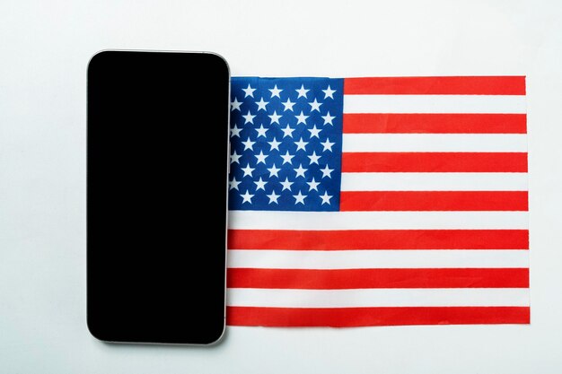 Las banderas de los EE.UU. o los Estados Unidos de América y un teléfono móvil con una pantalla en blanco sobre un fondo blanco Mockup o espacio de copia