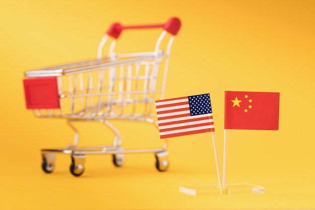 Banderas estadounidenses y chinas en el fondo de un carrito de supermercado vacío, el concepto de comercio entre países