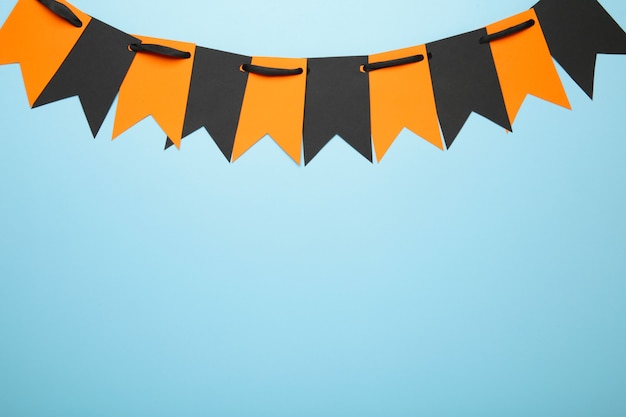 Banderas de fiesta en blanco y naranja para decoración de Halloween sobre fondo azul.