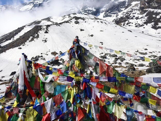 Banderas multicolores en la montaña cubierta de nieve contra el cielo