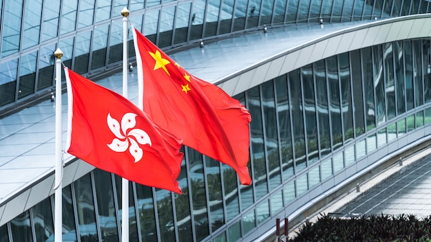 Las banderas nacionales de Hong Kong y China continental se unen con espacio de copia