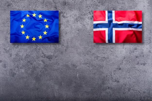 Banderas de Noruega y la Unión Europea sobre fondo de hormigón.