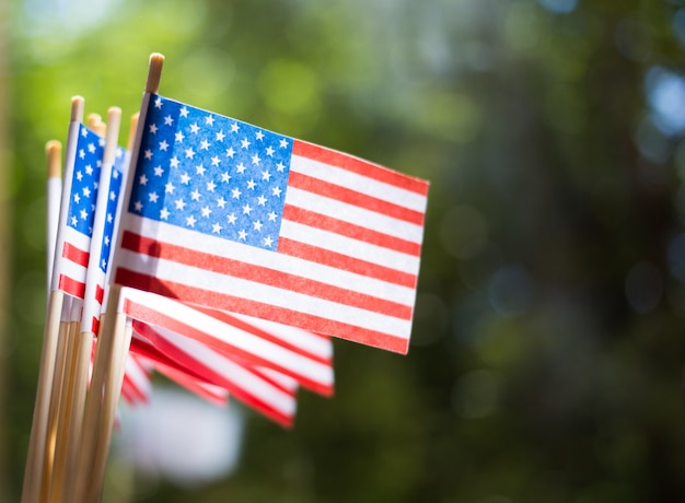 Banderas de papel en miniatura de Estados Unidos. Bandera americana en el fondo borroso al aire libre