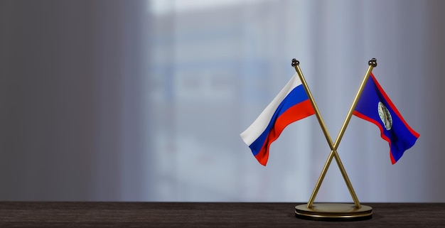 Banderas de Rusia y Belice en la mesa Negociación entre Belice y Rusia sobre un fondo poco borroso