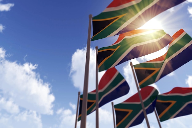 Banderas de sudáfrica ondeando en el viento contra un cielo azul d renderizado