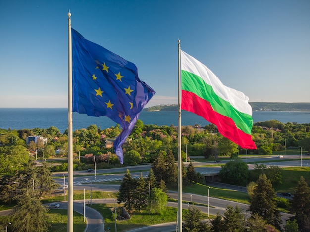 Banderas de la Unión Europea y Bulgaria contra la ciudad de Varna en el día de verano