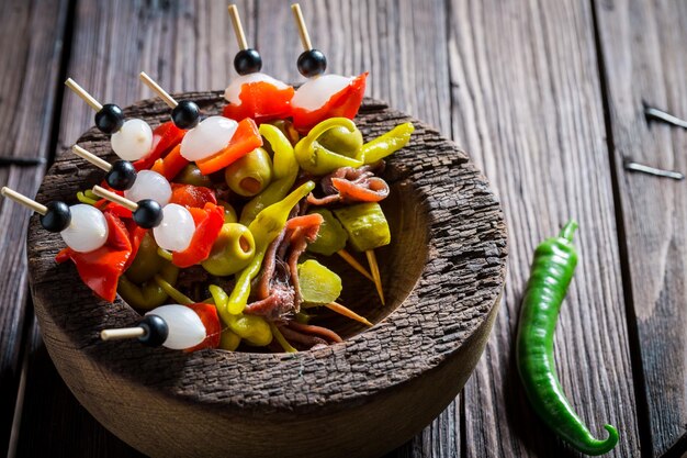 Banderillas com ingredientes frescos para corrida espanhola na mesa de madeira