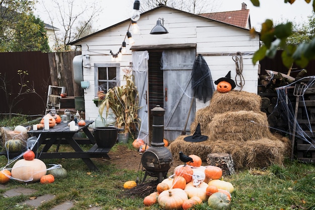 Bando de abóboras laranja para o halloween crânio branco grande chapéu de feiticeiro de corvo preto jackolantern com olhos esculpidos assustadoresboca Pilha de feno no celeiroDecoração de ruaentretenimento para crianças horror