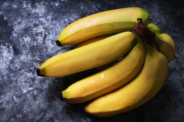 Bando de bananas na mesa rústica. Postura plana. Vista do topo