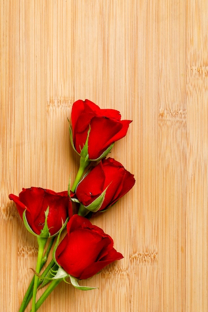 Foto bando de rosa vermelha e caixa de presente na placa de madeira. conceito de dia dos namorados