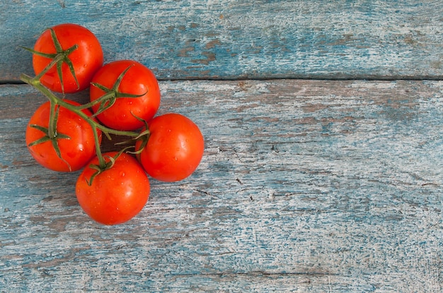 Bando de tomates com gotas no fundo de madeira velho