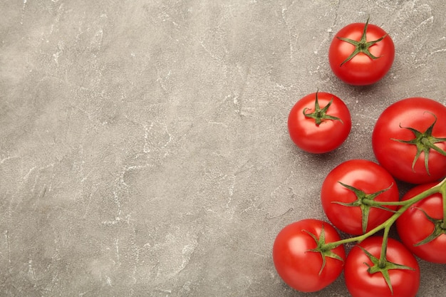 Bando de tomates frescos em fundo cinza Colheita de tomates Espaço para texto