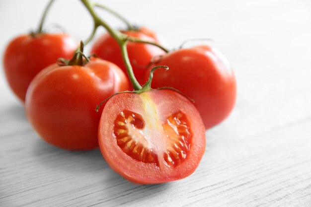 Bando de tomates suculentos vermelhos na luz de fundo de madeira