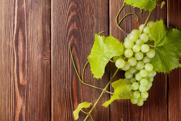 Bando de uvas brancas com folhas em madeira