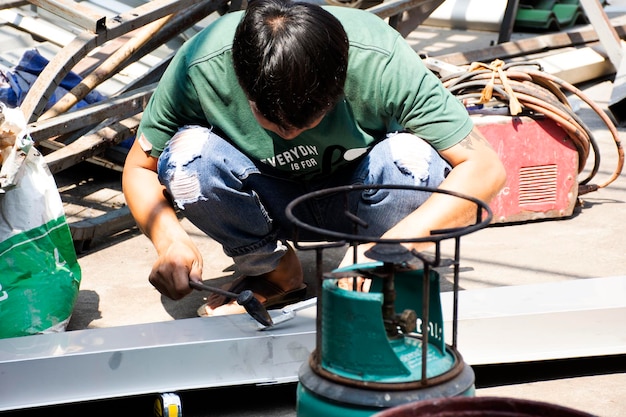 Bangcoc tailândia 9 de novembro trabalhadores tailandeses que trabalham e constroem e estrutura de soldagem manual do telhado do toldo na frente da casa no canteiro de obras em 9 de novembro de 2019 em bangkok tailândia