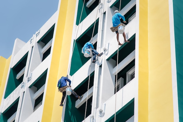 Bangkok Tailandia 23 de abril de 2017 Pintor de construcción asiático no identificado estaba subiendo el edificio por una cuerda con seguridad para pintar en la pared para mantenimiento, renovación o reparación