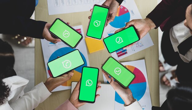 Bangkok/Thailand - 06. August 2021: Menschen halten Smartphones verschiedener Marken und verschiedener Betriebssysteme mit Logos von WhatApp, beliebten Social-Network-Messe-Anwendungen.