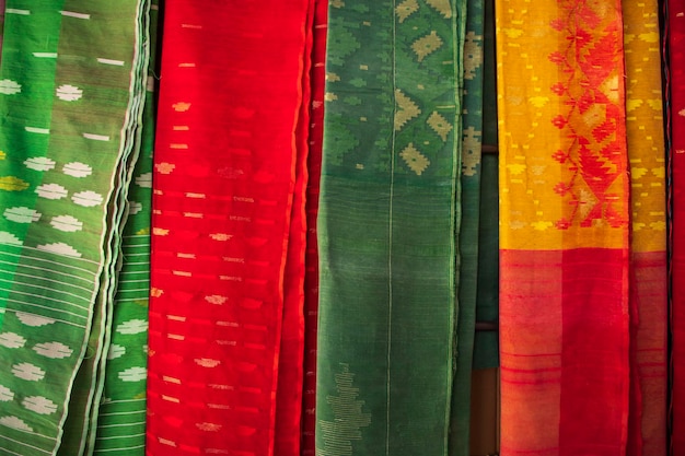 Bangladeschischer traditioneller farbenfroher Jamdani-Saree, der in den Ausstellungsräumen des Einzelhandels hängt