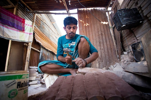 Bangladesh 02 de diciembre de 2017 Un artesano Mohamed Sohidul 29 está ocupado haciendo molinillos de piedra tradicionales conocidos popularmente como SheelPata en Dhaka