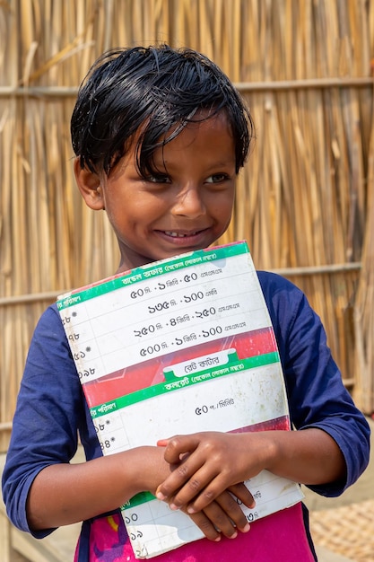 Bangladesh, 06 de março de 2021, Laila, 7 anos, uma estudante de aldeia olhando para o rosto tímido e segurando um livro em Majherchor Chandpur Chittagong