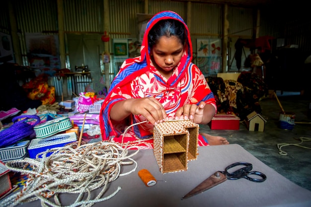 Bangladesh el 13 de mayo de 2018, un joven artesano está haciendo una obra maestra de las fibras de un árbol de plátano en Madhupur Tangail
