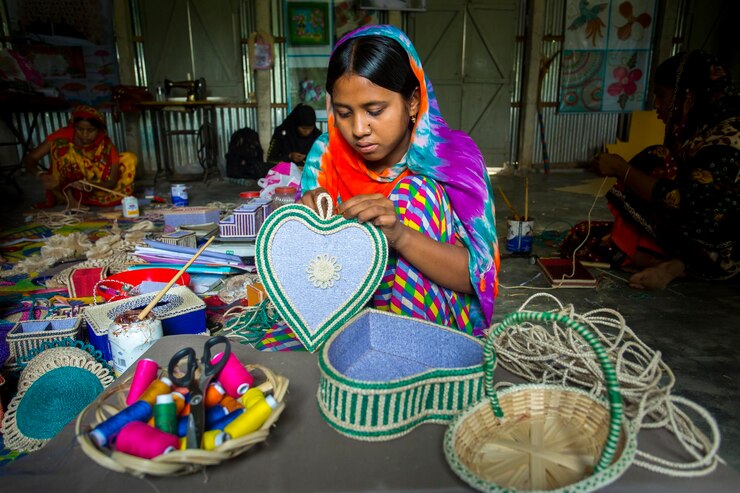 Bangladesh, 13 de mayo de 2018, una niña artesana de la aldea está haciendo en algunas cajas de exhibición usando fibra de piña en Madhupur Tangail