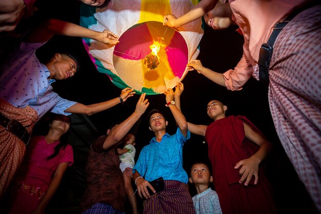 Foto bangladesh, 13 de octubre de 2019, la familia de devotos budistas libera linternas del cielo para adorar las reliquias de buda en el festival probarona purnima en bandarban, bangladesh