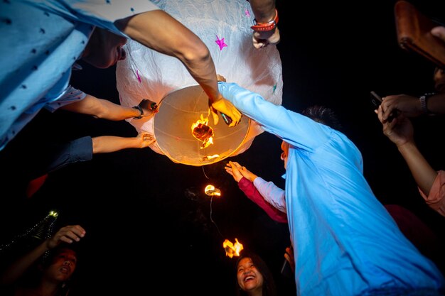 Foto bangladesh, 13 de octubre de 2019, la familia de devotos budistas libera linternas del cielo para adorar las reliquias de buda en el festival probarona purnima en bandarban, bangladesh